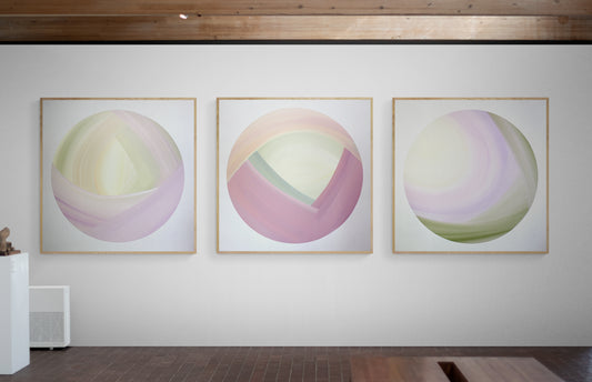Three large abstract paintings on a white wall.